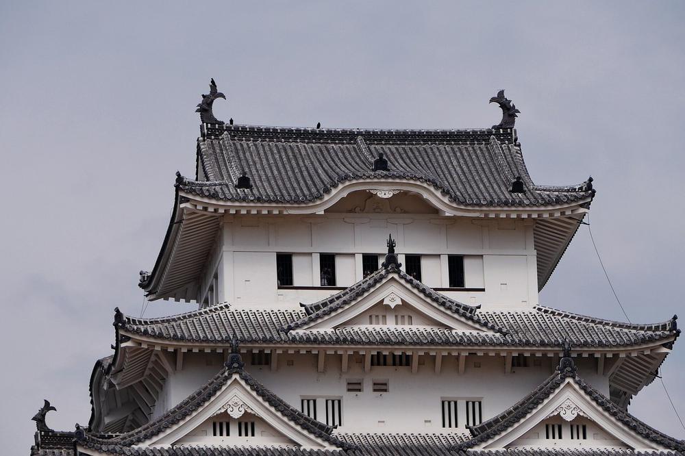 The stone keep of Himeji Castle above its white walls The stone keep of Himeji Castle above its white walls