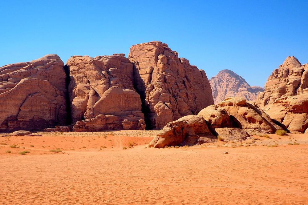 Sandstone towers rising from red sand in Wadi Rum Sandstone towers rising from red sand in Wadi Rum