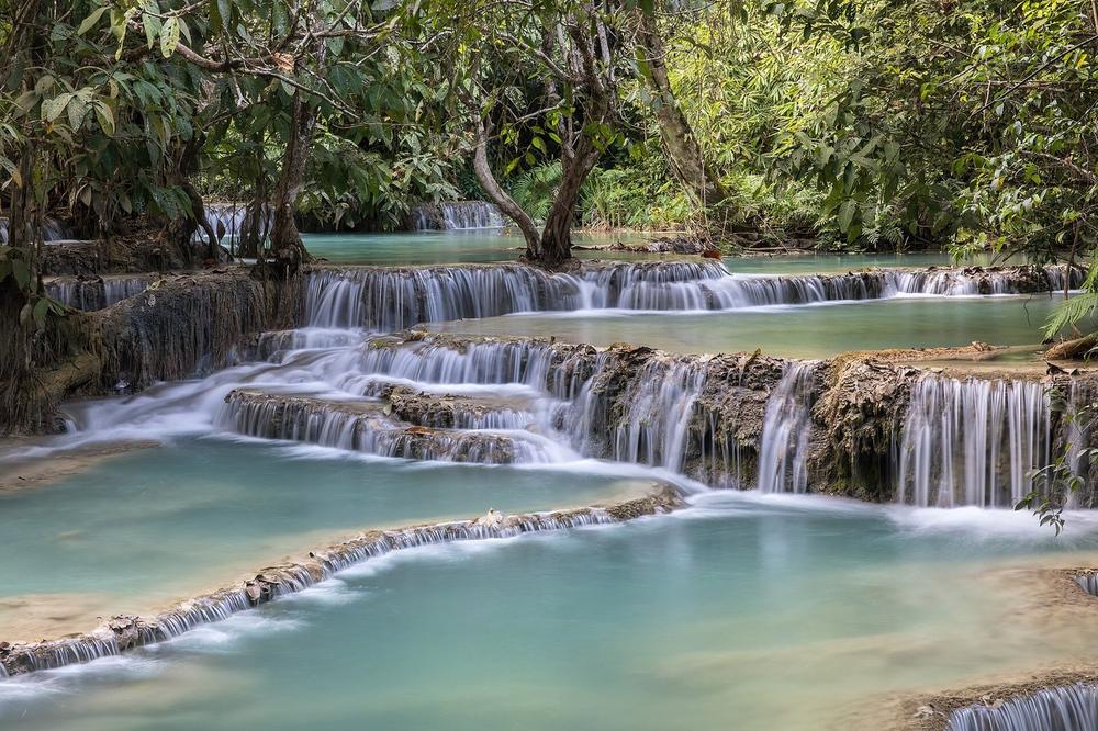 Turquoise limestone pools stepping down through forest at Kuang Si Turquoise limestone pools stepping down through forest at Kuang Si