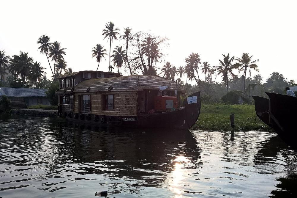A houseboat moored in a narrow backwater canal near Alleppey A houseboat moored in a narrow backwater canal near Alleppey