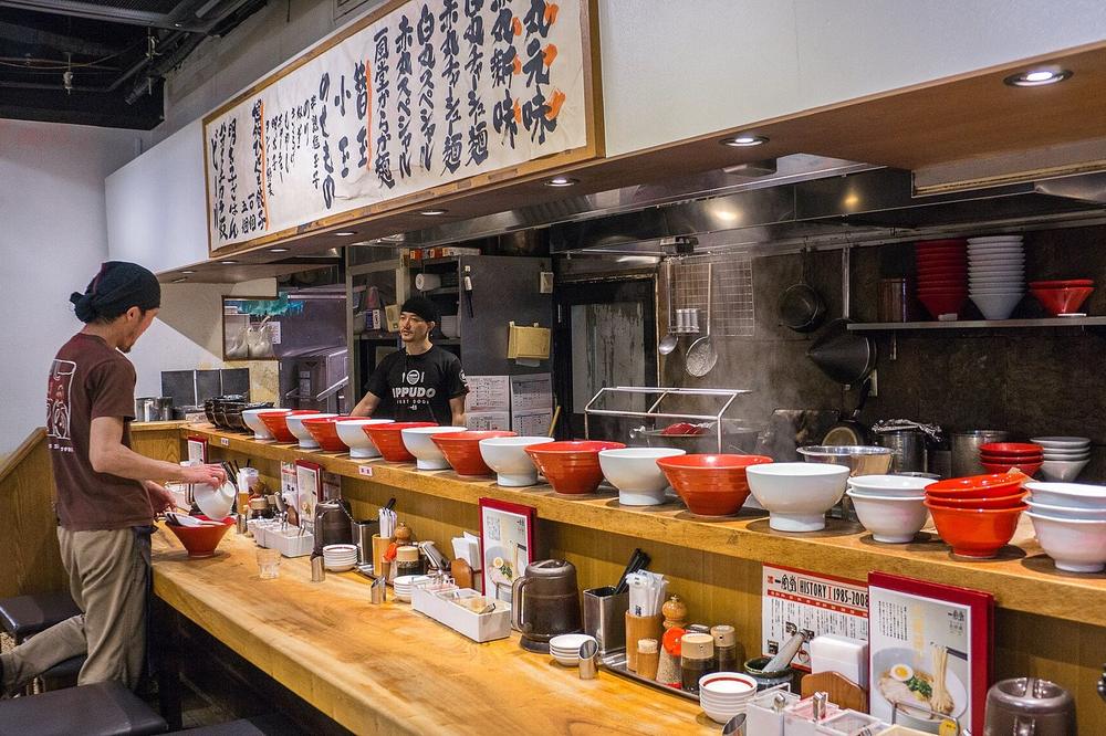 A narrow counter restaurant with eight seats and one cook A narrow counter restaurant with eight seats and one cook
